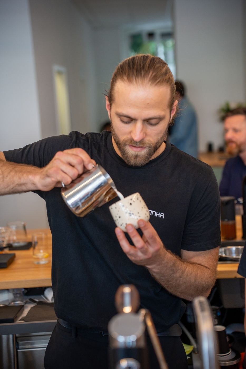 Norbert Tinka giesst Milch in einen Cappuccino